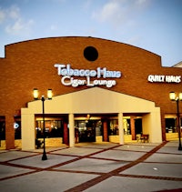 a building with a sign that says tobacco house cigar lounge